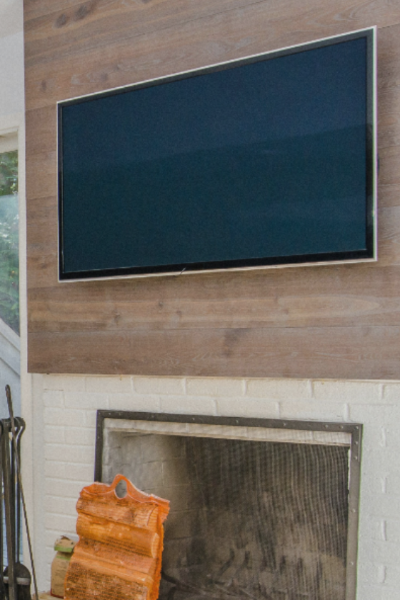 TV mounted on a wall integrated with a modern black shelving unit